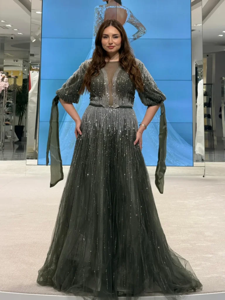 Model wearing a dark green full skirt gown in store.