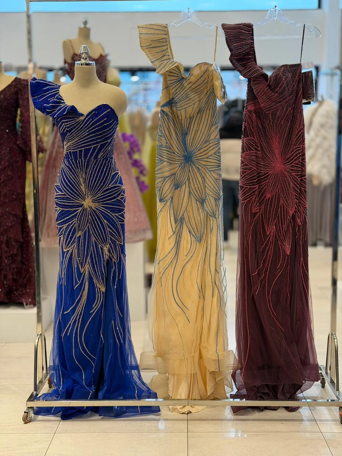 Colorful evening gowns displayed on a boutique clothing rack