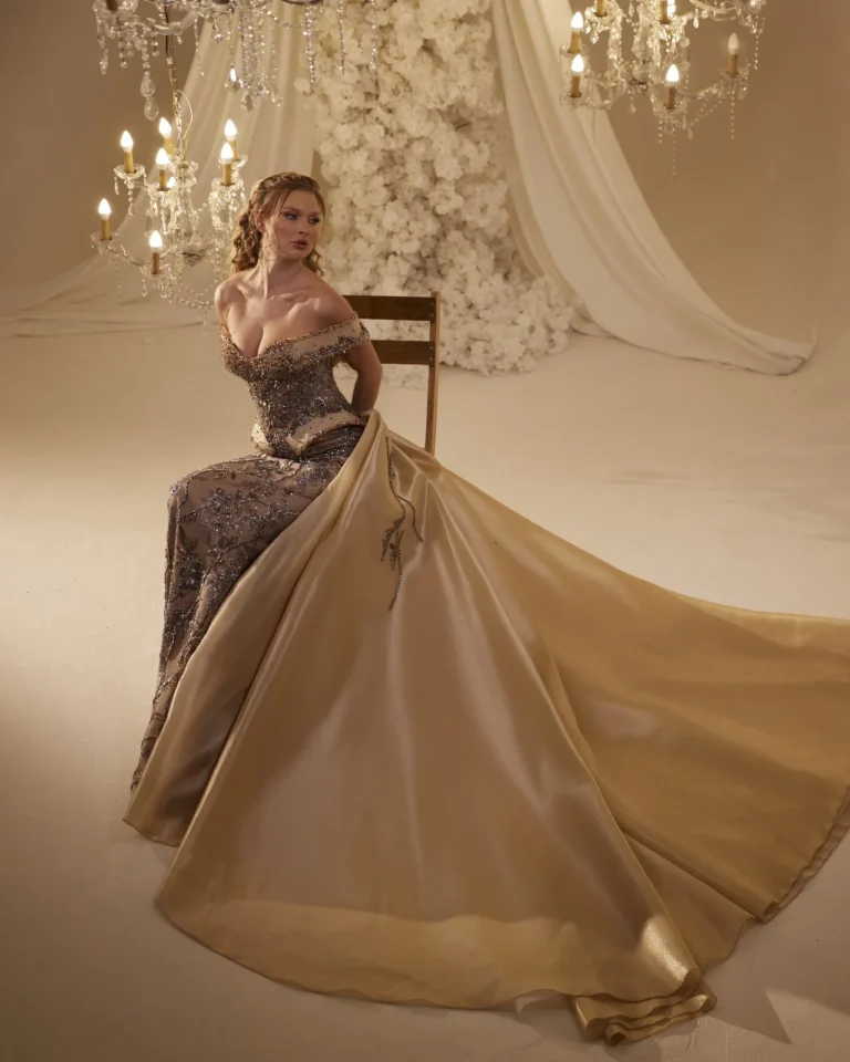 Model wearing a gold evening gown flowing skirt.