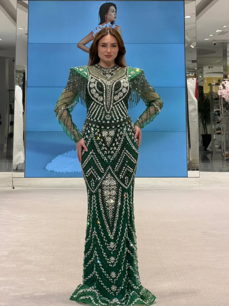 Model wearing a green patterned gown front in store.