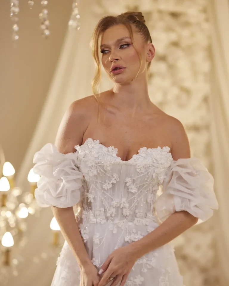 Model wearing a ivory bridal gown lace neckline.