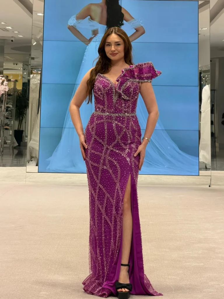 Model wearing a magenta evening gown front in store.