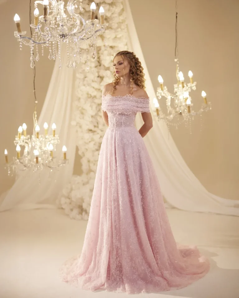 Model wearing a pink evening gown full length.