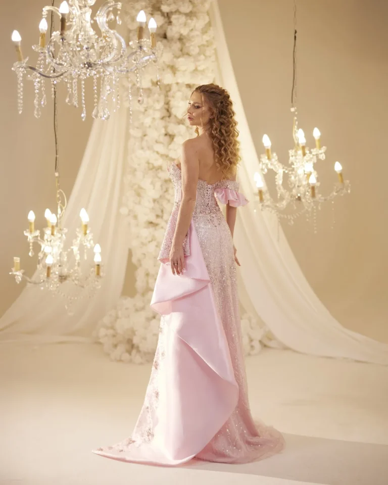 Model wearing a pink evening gown side profile.