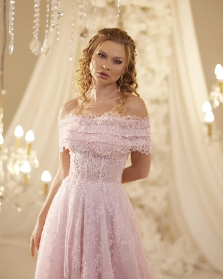 Model wearing a pink gown off shoulder neckline.