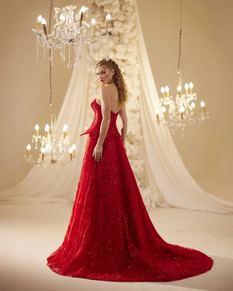 Model wearing a red evening gown long train.