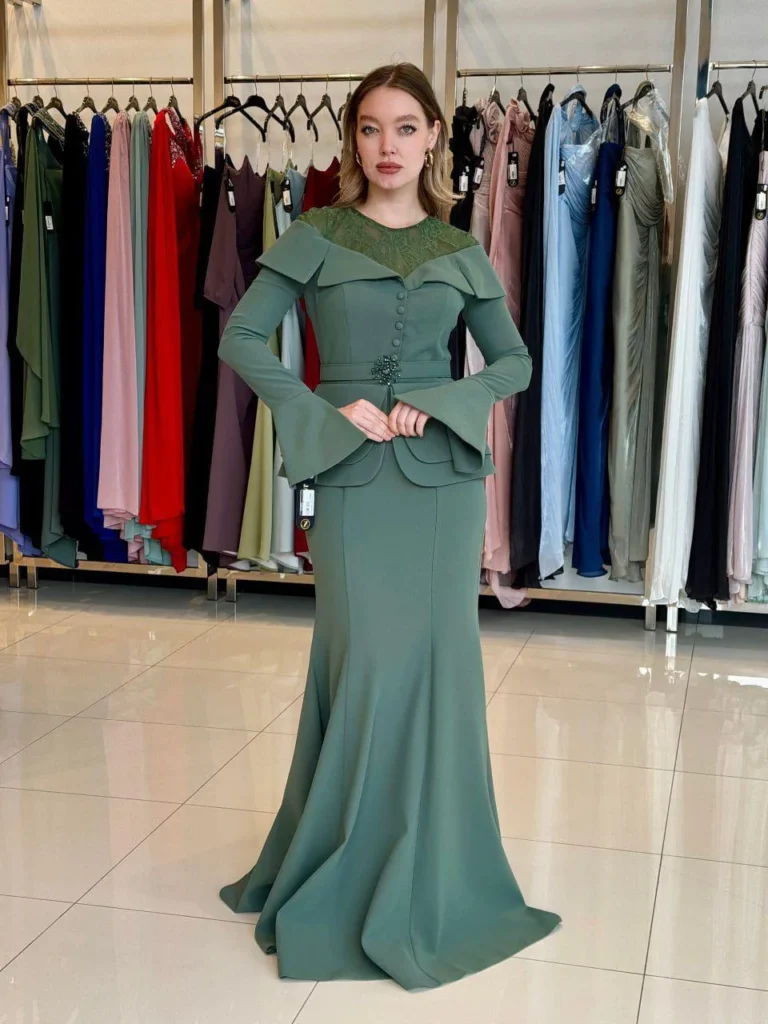 Model wearing a sage green evening gown front in store.