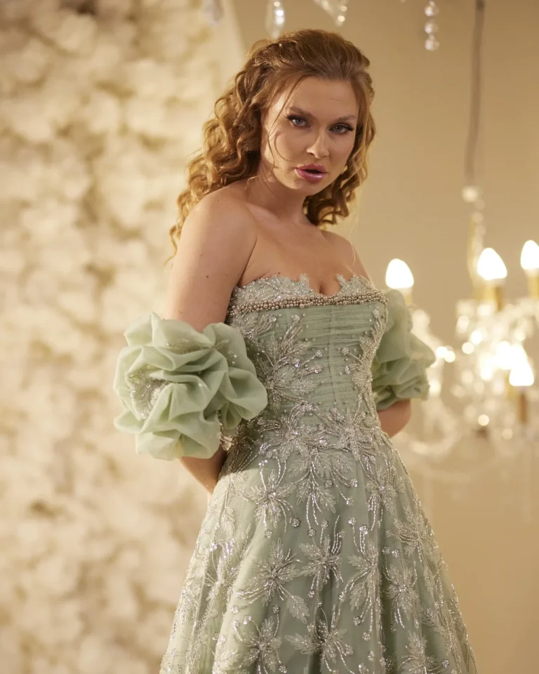 Model wearing a sage green gown floral neckline.
